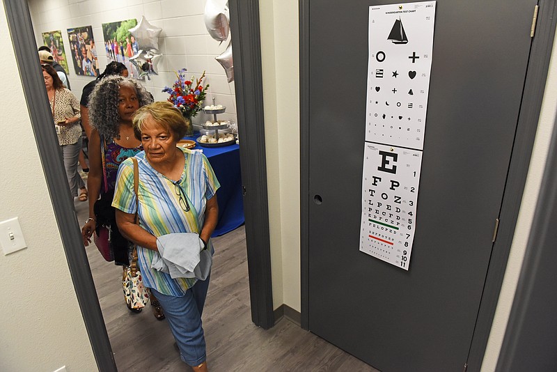 Marion Tyler (front) and Del Johnson tour the new Mainline Health Pulaski County Special School District Health Center during the ribbon cutting event Friday at Mills Middle School..(Arkansas Democrat-Gazette/Staci Vandagriff)