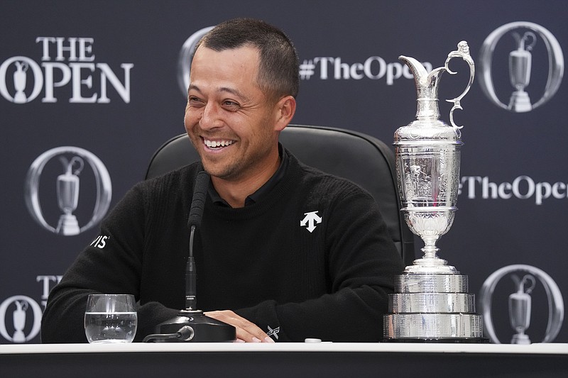 Xander Schauffele of the United States reacts as he sits with the Claret Jug trophy at a press conference after winning the British Open Golf Championships at Royal Troon golf club in Troon, Scotland, Sunday, July 21, 2024. (AP Photo/Jon Super)