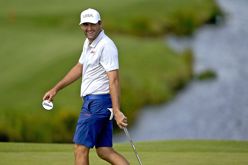 Scottie Scheffler, of the United States, smiles on the 11th green during a practice round for the men's golf event at the 2024 Summer Olympics, Monday, July 29, 2024, at Le Golf National in Saint-Quentin-en-Yvelines, France. (AP Photo/Matt York)