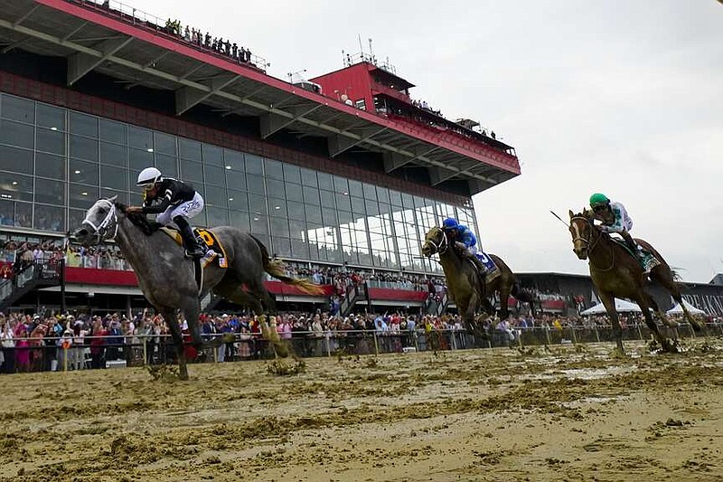 Jaime Torres, left, atop Seize The Grey, crosses the finish line in front of Flavien Prat, center, atop Catching Freedom, and Brian Hernandez, Jr., atop Mystik Dan, while winning the Preakness Stakes horse race at Pimlico Race Course, Saturday, May 18, 2024, in Baltimore. (AP Photo/Julio Cortez)