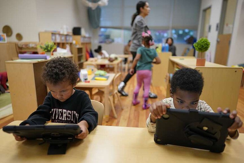 Children work on tablets during a preschool class at the Life Learning Center - Head Start, in Cincinnati, Tuesday, Nov. 21, 2023. (AP Photo/Carolyn Kaster)