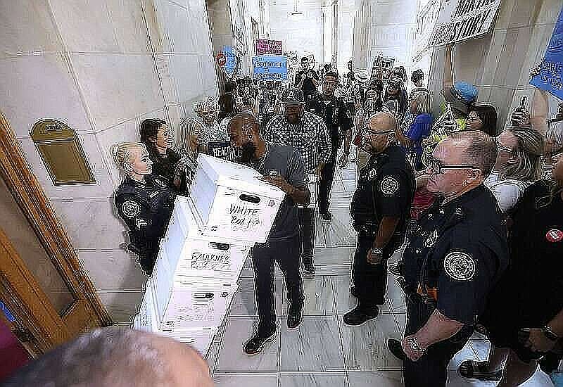 Capitol Police escort movers as they bring the abortion amendment petitions into the state Capitol on Friday. (Arkansas Democrat-Gazette/Thomas Metthe)