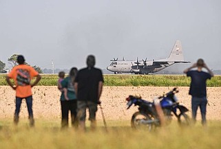 A C-130 taxis along U.S. 63 in Bono for an Air Force training exercise Sunday morning as locals watch from afar. See more photos at arkansasonline.com/85bono/. (Arkansas Democrat-Gazette/Staci Vandagriff)