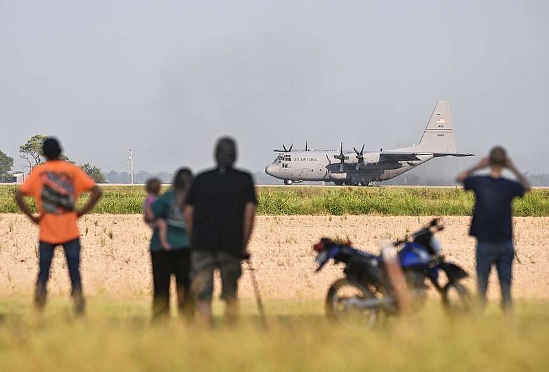 A C-130 taxis along U.S. 63 in Bono for an Air Force training exercise Sunday morning as locals watch from afar. See more photos at arkansasonline.com/85bono/. (Arkansas Democrat-Gazette/Staci Vandagriff)