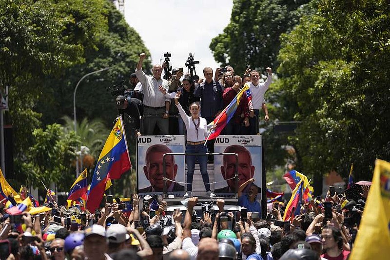 Opposition leader Maria Corina Machado holds a national flag while waving to supporters as she arrives for a rally in Caracas, Venezuela, Saturday, Aug. 3, 2024. (AP Photo/Matias Delacroix)