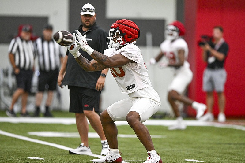 Arkansas tight end Var’keyes Gumms (30) catches a pass in front of tight ends coach Morgan Turner on Thursday during the Razorbacks’ second preseason practice.
(NWA Democrat-Gazette/Hank Layton)