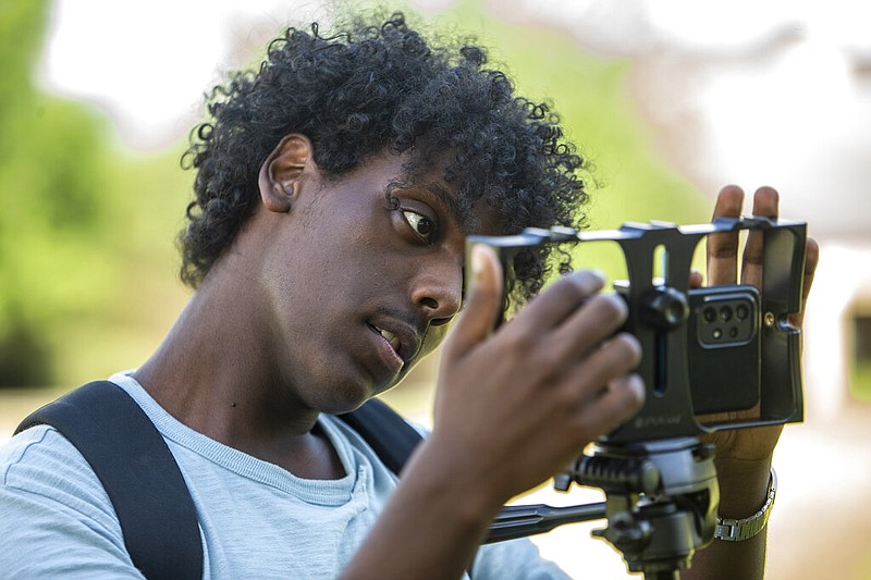 Filmmaker Kaleab Kurtz sets up his camera before filming a scene in his movie "Life" on location in Greensboro, N.C., on Friday, July 1, 2022. (Woody Marshall/News & Record via AP)