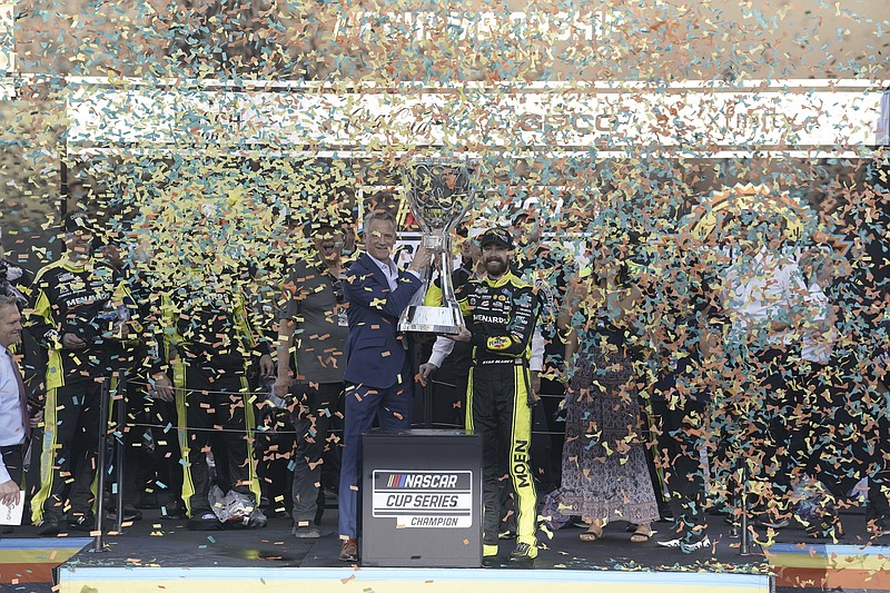 Ryan Blaney, right, receives the NASCAR Cup Series Championship Cup from NASCAR president Steve Phelps after capturing winning it at Phoenix Raceway, Sunday, Nov. 5, 2023, in Avondale, Ariz. (AP Photo/Darryl Webb)