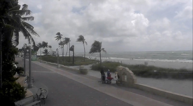 People walk along a windy Hollywood Beach as Tropical Storm Debby moves through the Gulf of Mexico toward Florida on Sunday, Aug. 4, 2024 in Hollywood, Fla. (WPLG via AP)