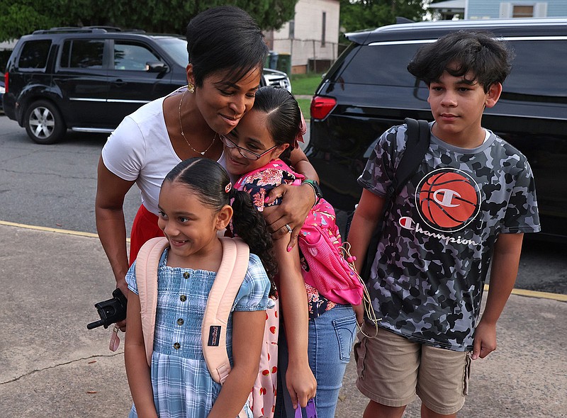 Gibbs International Magnet School Principal Tina Greenwood, upper left, greets students Paola Jimenez, 6, left, Guadalupe Isabel Jimenez, 9, center, and Jorge Jimenez, 10, on the first day of classes Monday, Aug. 14, 2023. (Arkansas Democrat-Gazette/Colin Murphey)