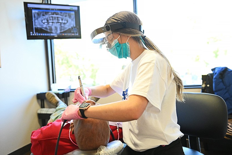 Tiffany Hogue, a dental hygienist, cleans Christopher Butler’s teeth during Operation Stand Down, a free dental care event for veterans, at Dr. Ned Alley’s clinic in Little Rock in this Nov. 3, 2023, file photo. (Arkansas Democrat-Gazette/Staci Vandagriff)